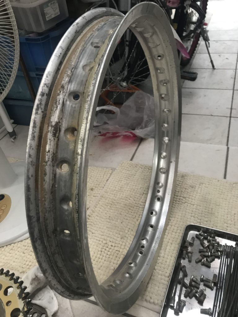 サビが進行し一部が折れたKDX125のリアスポークと取り外したホイールのリム