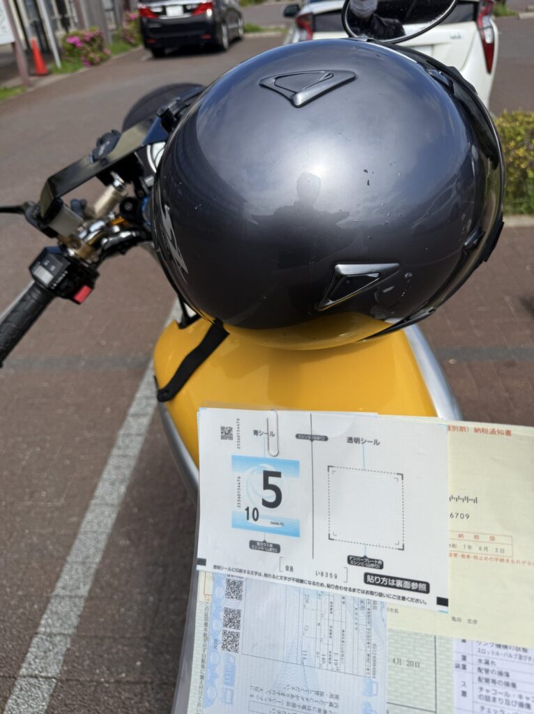 車検無事通過。駐車場のvmax1200の上で記念にシールを撮影。